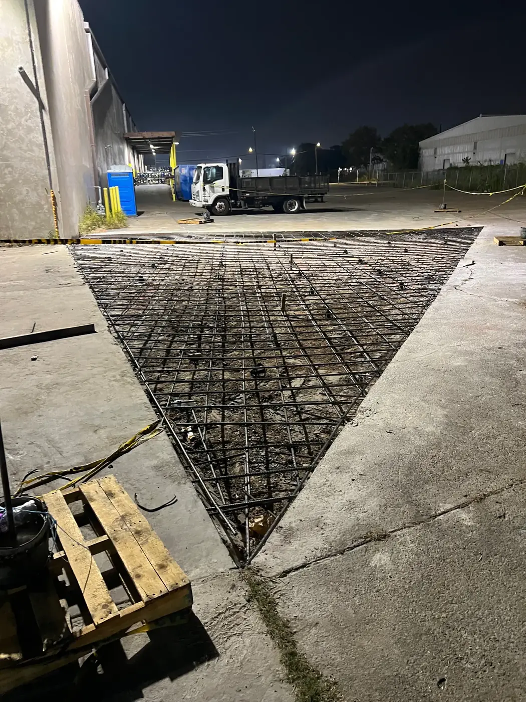 Night concrete slab preparation with rebar installed before pour
