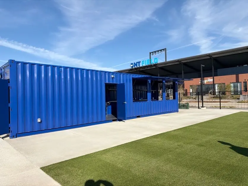 Blue commercial container modification installed beside a stadium venue